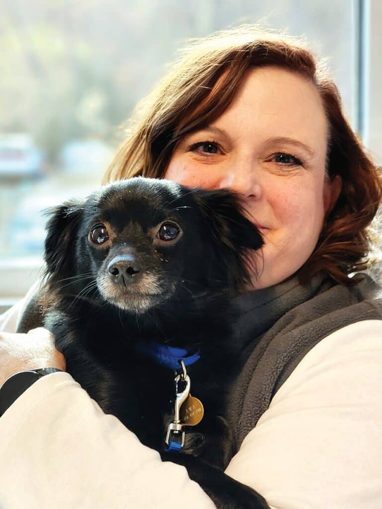 Animal Welfare Association Executive Director Laura Houston holding pet dog.