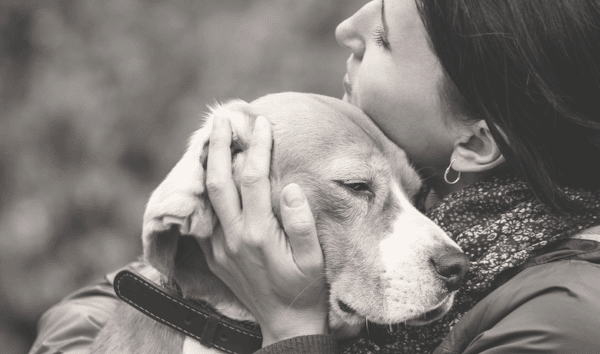 Woman holding dog in black and white