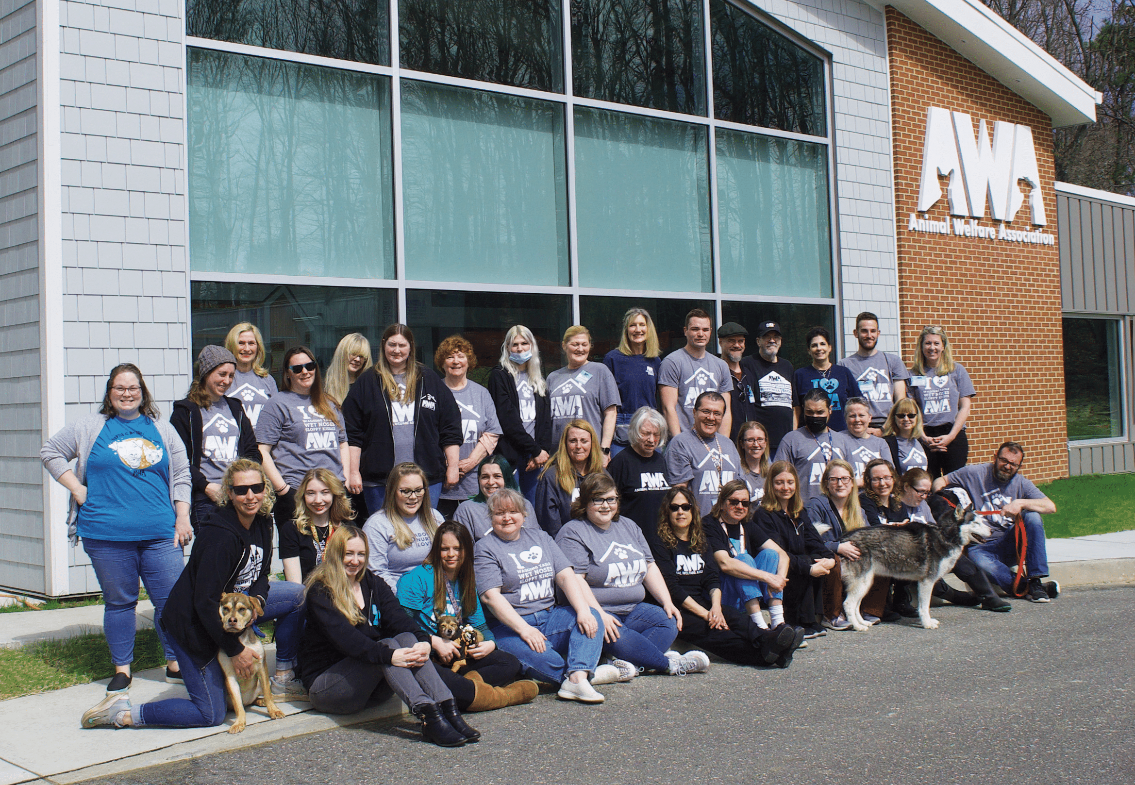 Group of AWA employees taking picture in front of new Adoption Center.