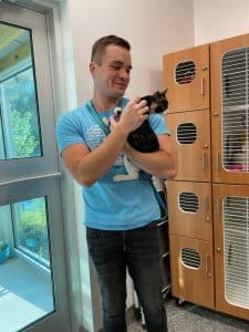 Animal Welfare Association Foster and Transport Coordinator Cole Ogren holding cat.