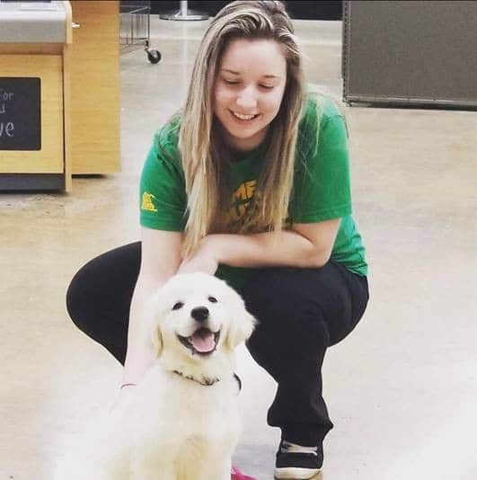 Animal Welfare Association Behavior Assistant Abby Pukenas petting dog.