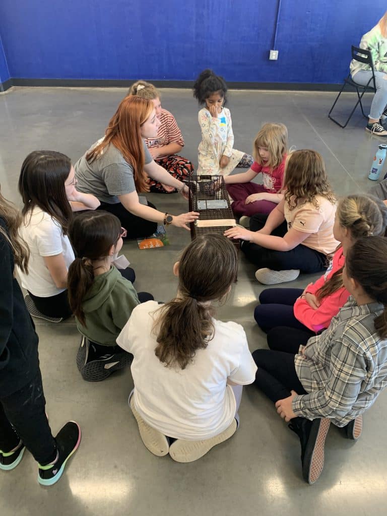 Kids and teacher in circle learning at Animal Welfare Association camp