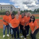 Volunteers in orange shirts taking picture at AWA Paws & Feet 2023.