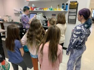 Group of children taking tour of Animal Welfare Association's medical center with vet tech.