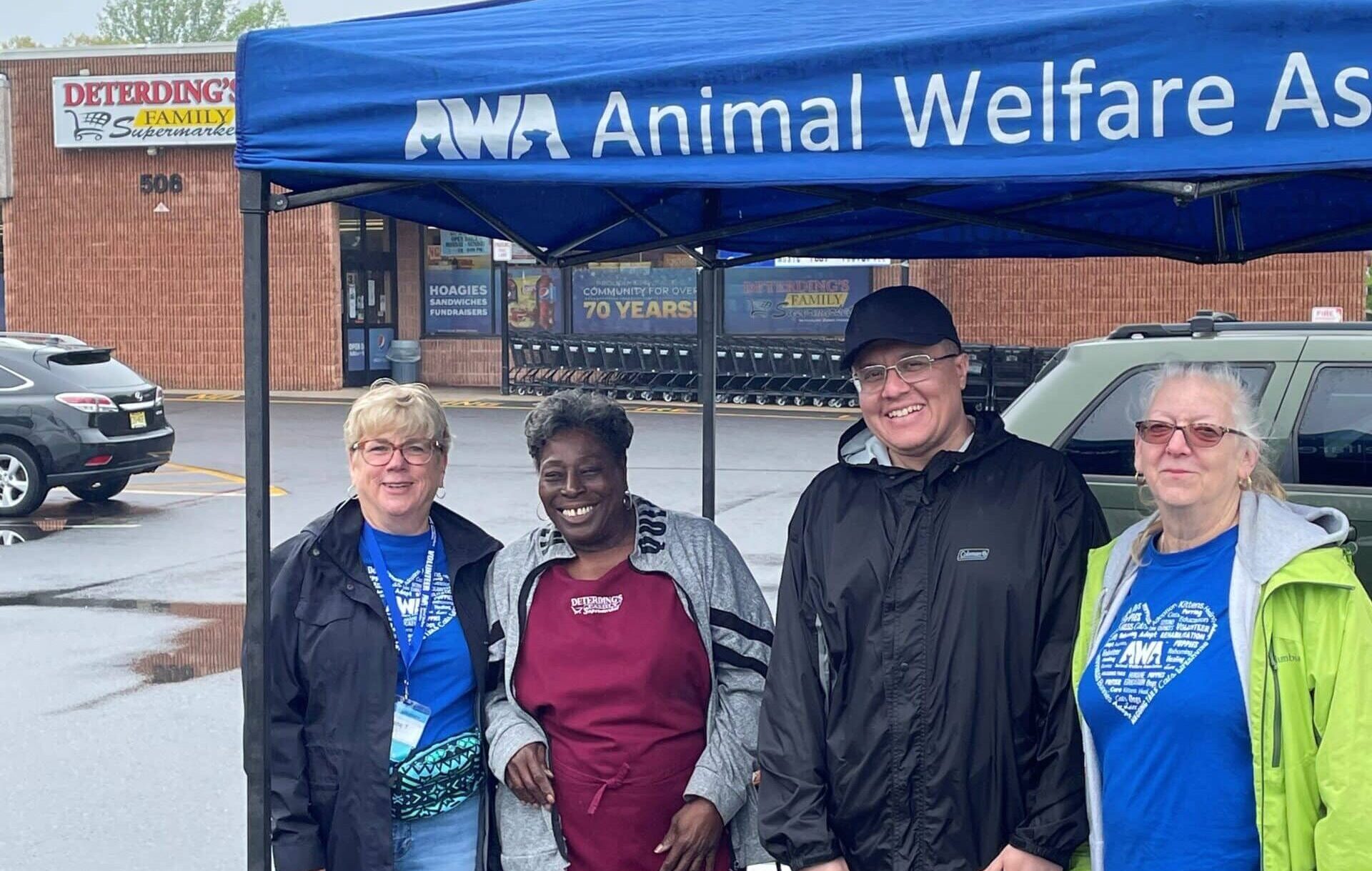 Three volunteers and employee outside for Animal Welfare Association outreach event at Deterding's grocery store.