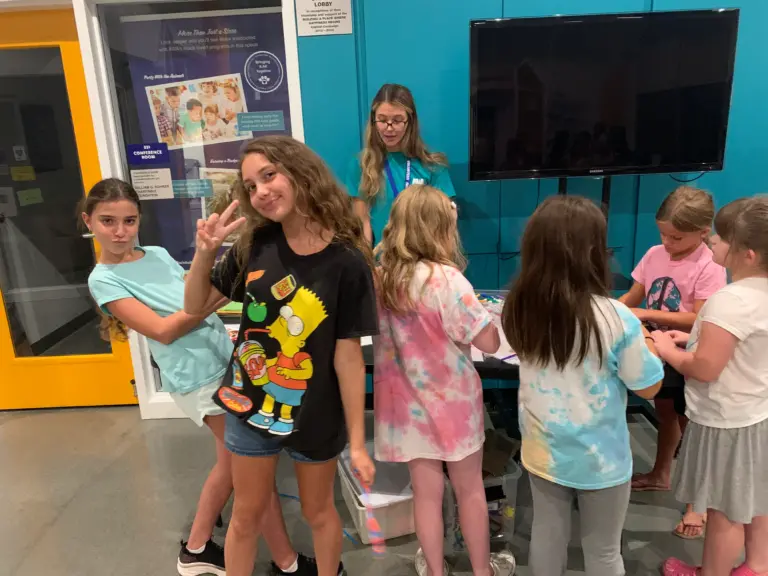 Children posing for picture while doing activity at Animal Welfare Association's Education event.