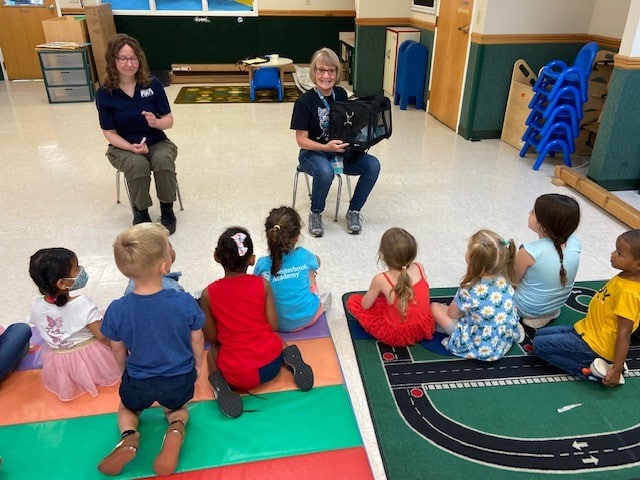 Two women doing presentation with students at an AWA education outreach visit.