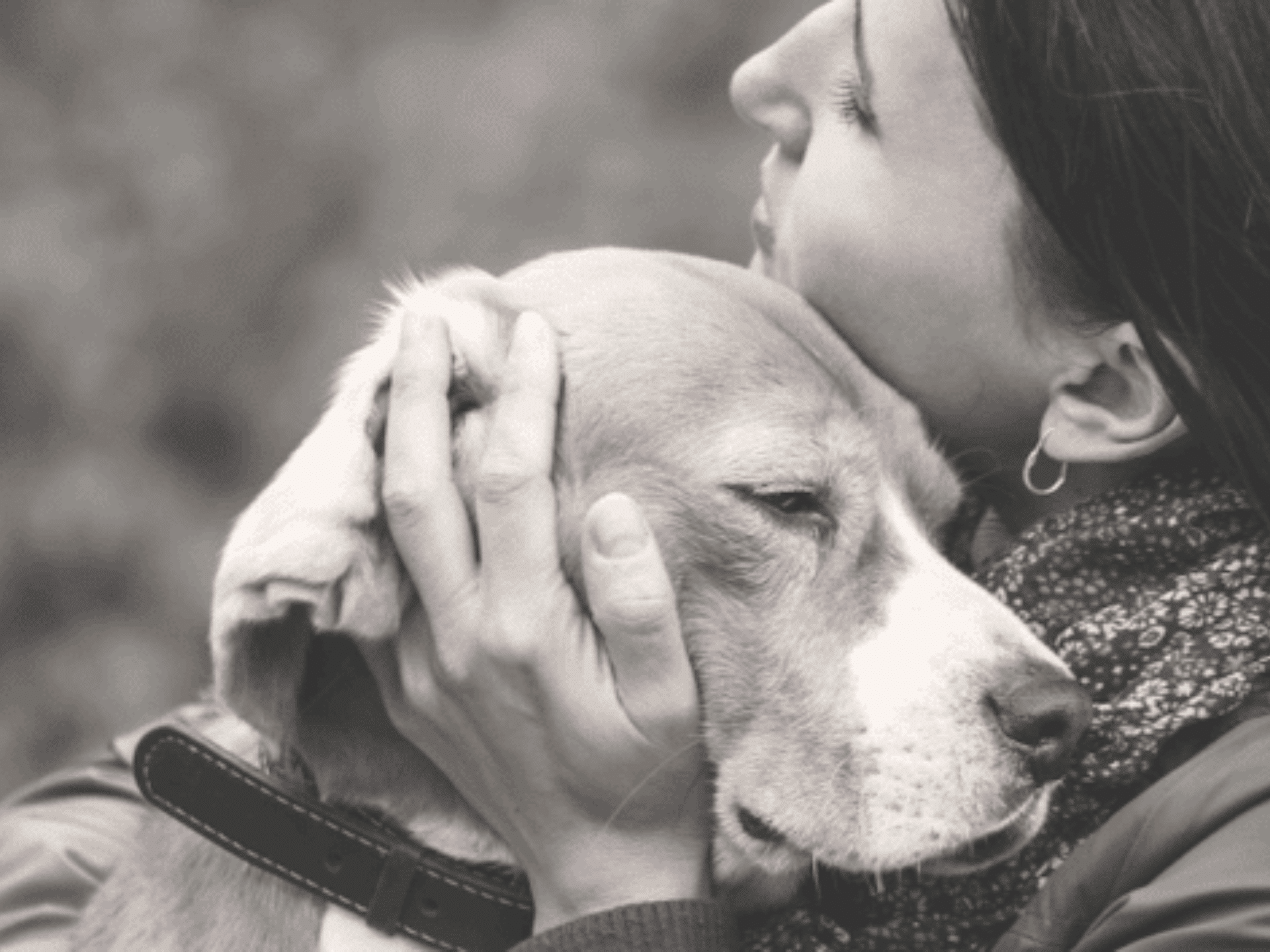 Woman holding dog in black and white