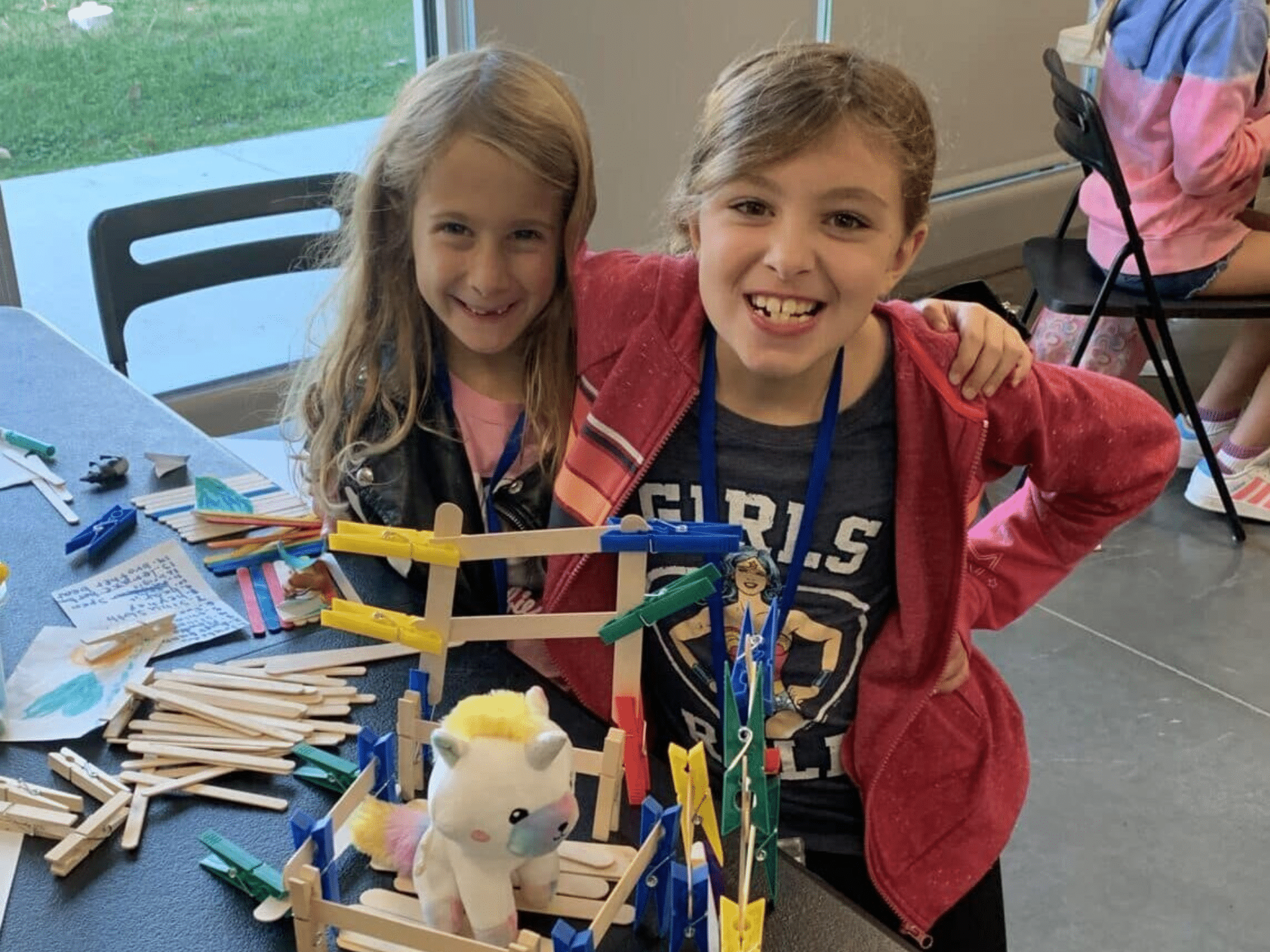Two children making animal crafts at AWA Education program.